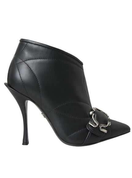 a black high heeled shoe with a metal buckle