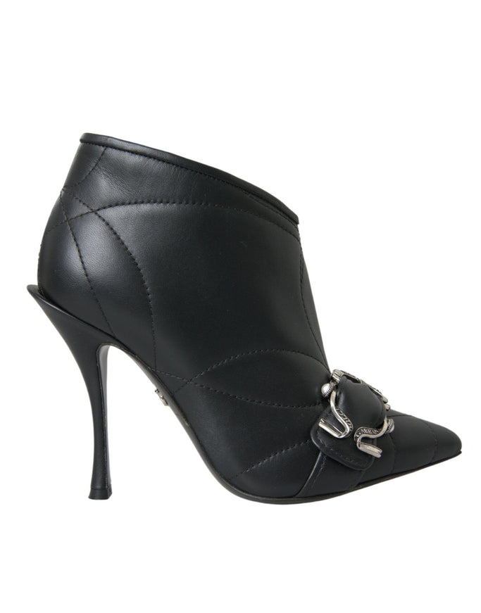 a black high heeled shoe with a metal buckle