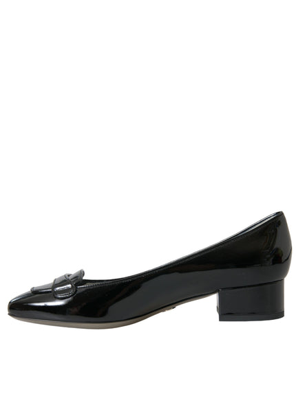 a pair of black shoes with a bow on the heel