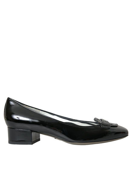 a pair of black shoes with a bow on the heel