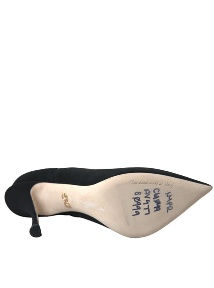 a woman's black high heeled shoe on a white background