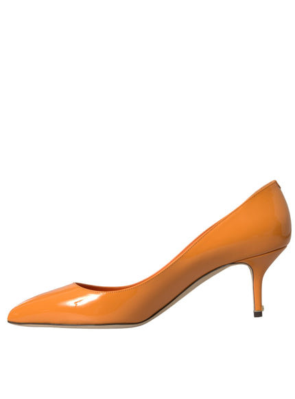 a woman's orange high heeled shoe on a white background