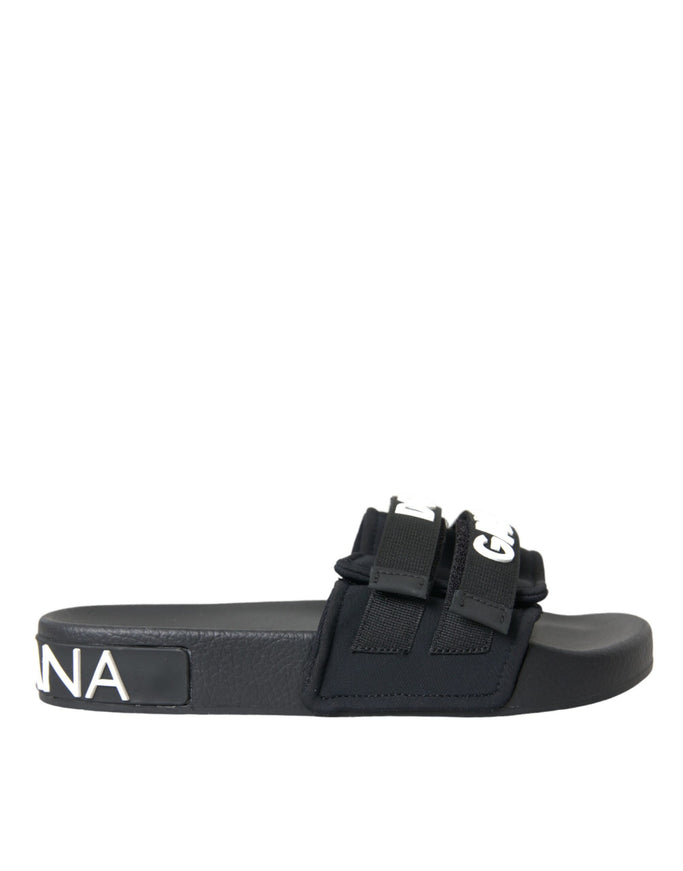 a black and white slider sandal with a logo on the side