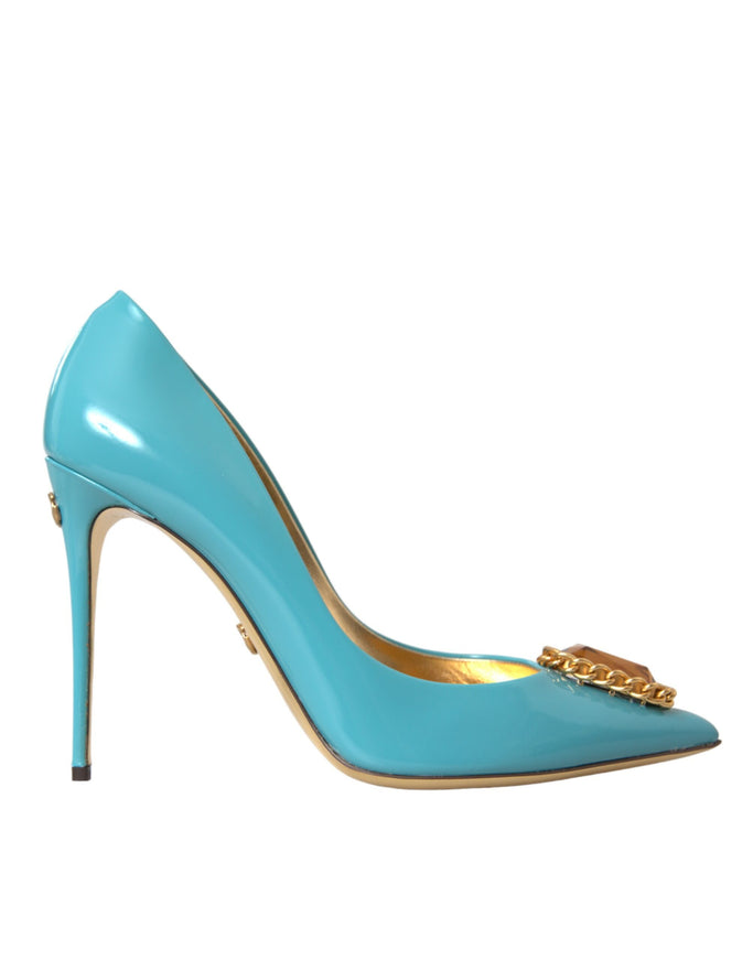 a blue high heeled shoe with a gold chain