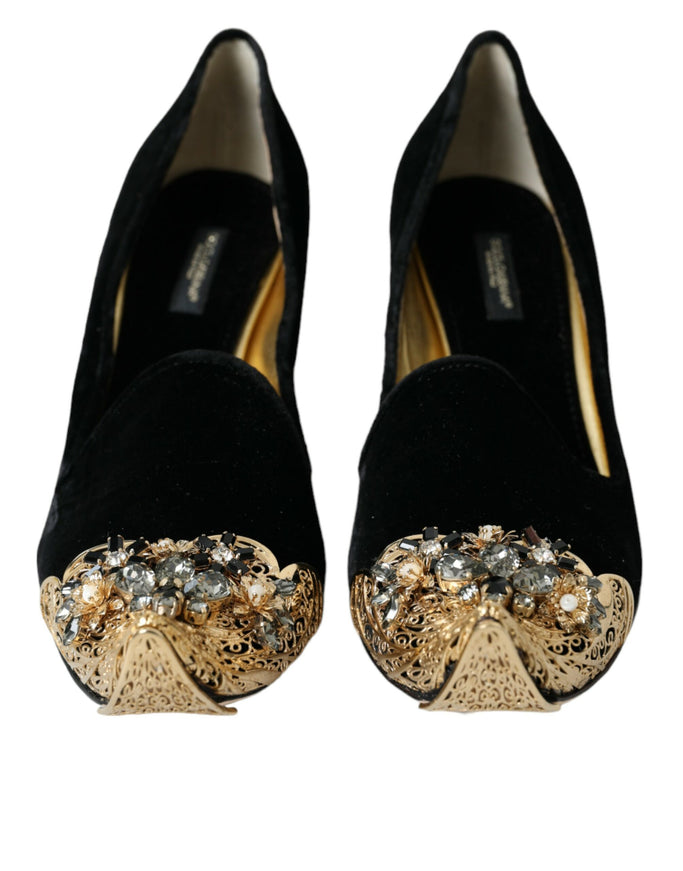 a pair of black shoes with a gold bow