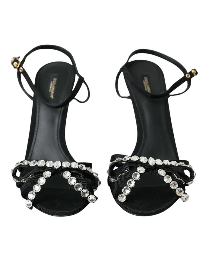 a pair of black sandals with a jewel embellishment