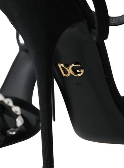 a pair of black high heels with a gold logo