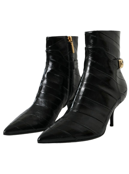 a pair of black boots with gold buckles