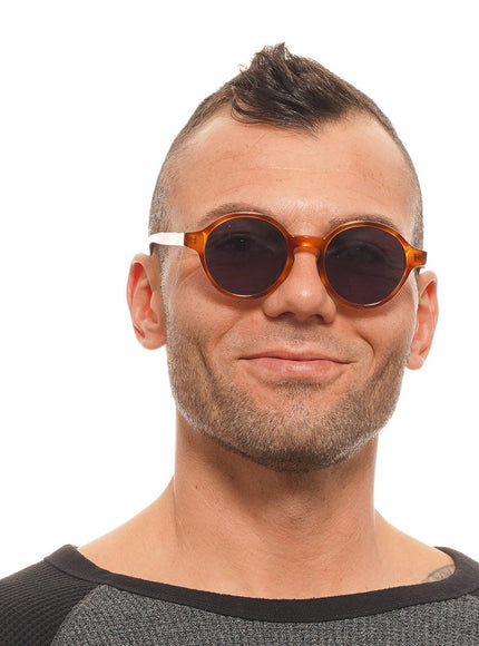 a man wearing a pair of round sunglasses