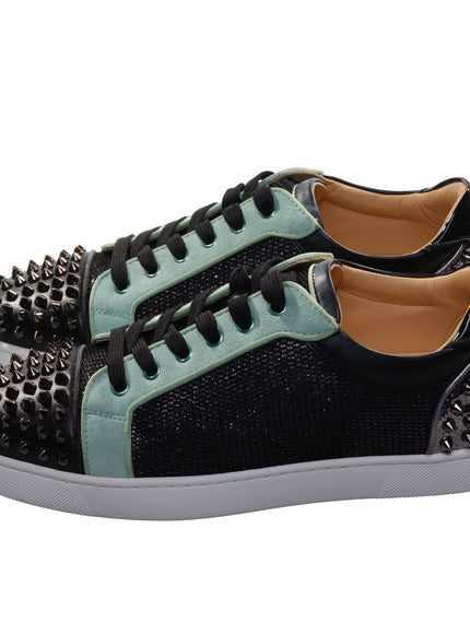 a pair of black and green sneakers with spikes