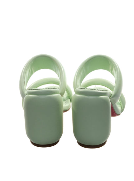 a pair of green shoes sitting on top of a white floor