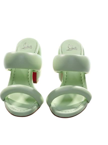 a pair of green sandals on a white background