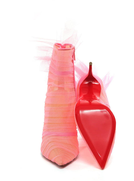 a pink vase with a red spoon next to it