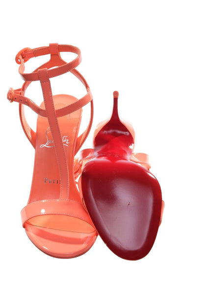 a pair of red high heeled shoes next to a red pepper