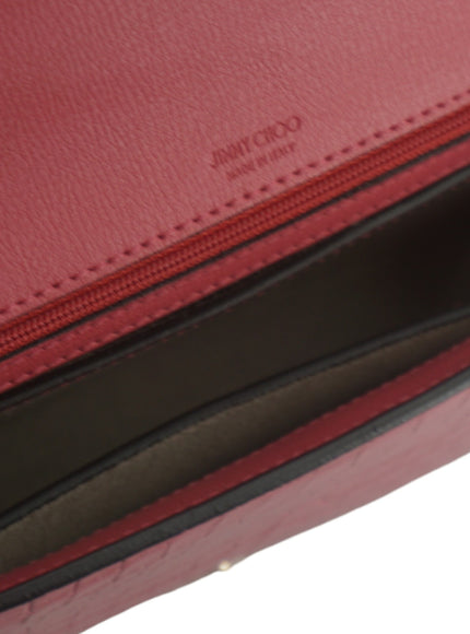 a close up of a red purse on a white background