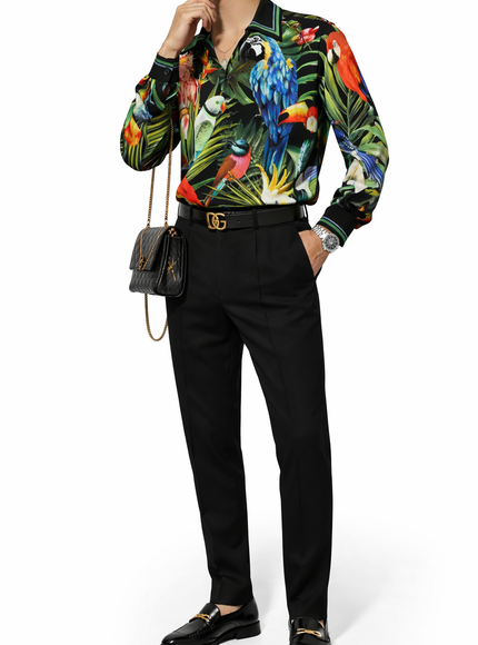 Person wearing a colorful tropical-themed shirt with black pants and shoes on a white background