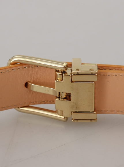 a gold buckle on a tan leather belt