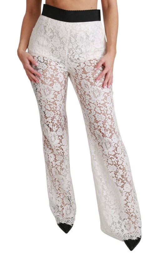 a woman wearing white lace pants and a bra