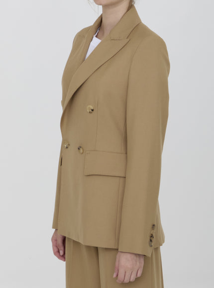 a woman wearing a tan suit and hat