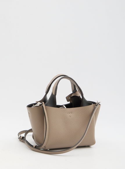 a beige purse with a black handle on a white background