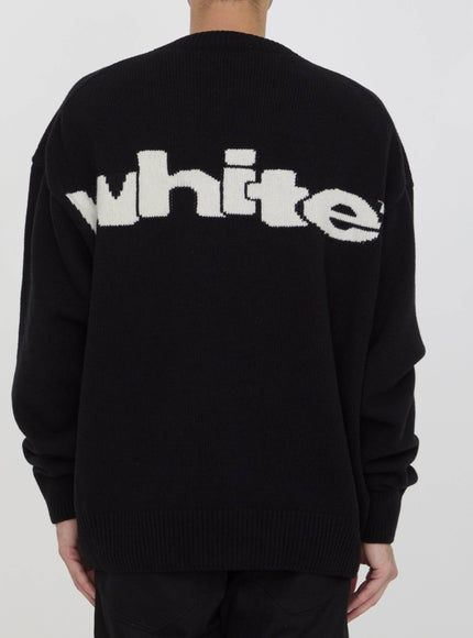 a man wearing a black sweater with white letters on it