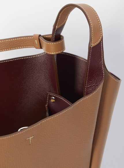 a brown purse with a cross on the inside of it