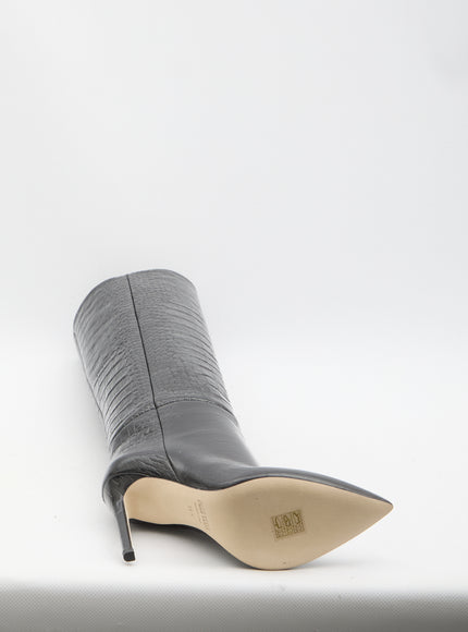 a pair of black high heeled shoes on a white surface