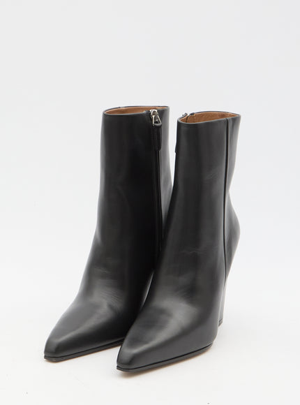 a pair of black ankle high boots with zippers