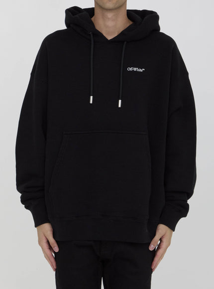 a man wearing a black hoodie with a white logo on it