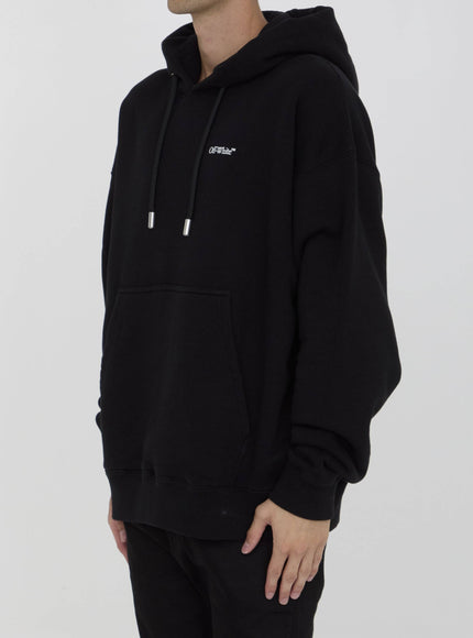 a man wearing a black hoodie with a white logo on it