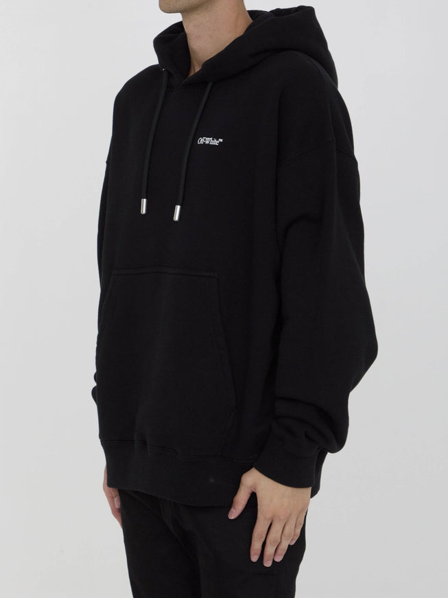 a man wearing a black hoodie with a white logo on it