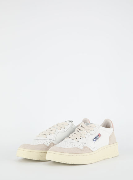 a pair of white and beige sneakers on a white background