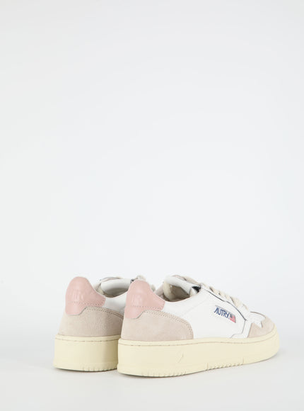 a pair of white and pink sneakers on a white background