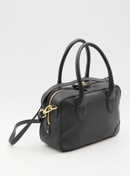 a black handbag with a gold zipper