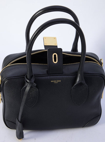 a black handbag with a gold handle on a white background