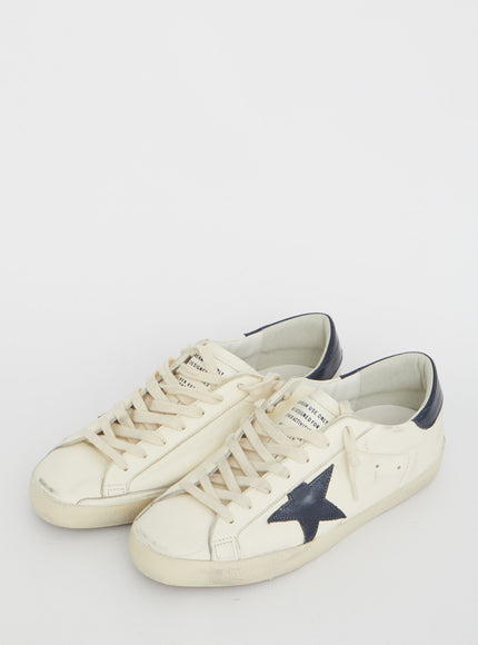 a white sneaker with a blue star on the side