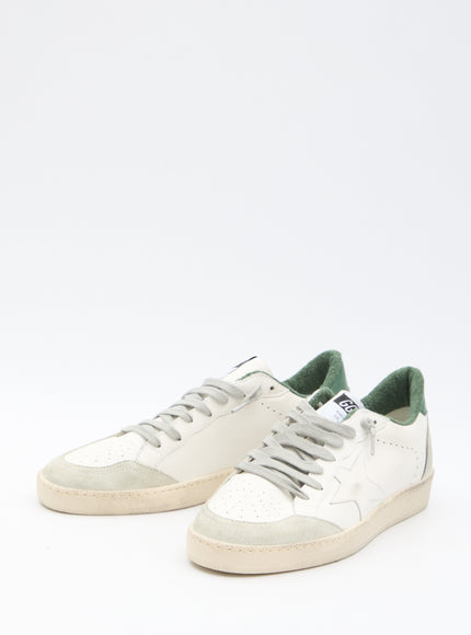 a pair of white and green sneakers on a white background