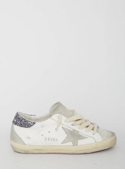 a white sneaker with a silver star on the side