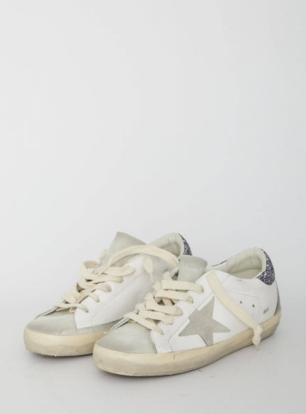 a pair of white sneakers with a star on the side