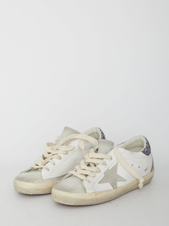 a pair of white sneakers with a star on the side