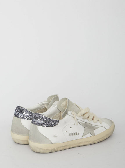 a pair of white and silver sneakers on a white background