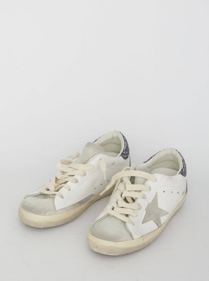 a pair of white sneakers with a star on the side