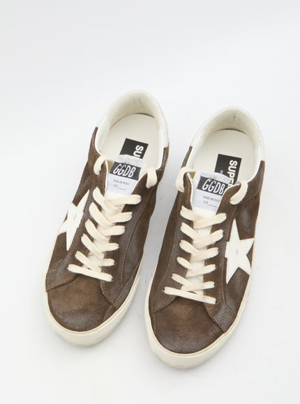 a pair of brown and white sneakers on a white surface