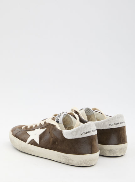 a pair of brown and white sneakers on a white background