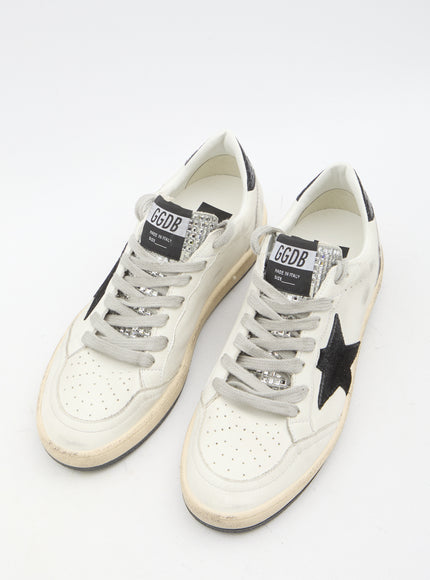 a pair of white sneakers with a black star on the side