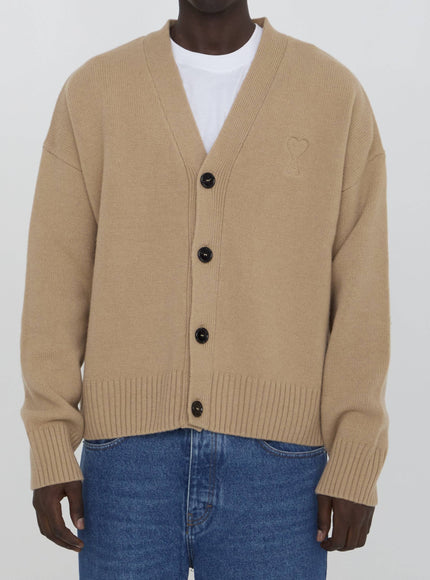 a man wearing a tan cardigan sweater and jeans