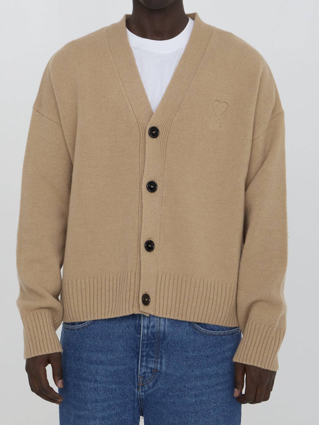 a man wearing a tan cardigan sweater and jeans