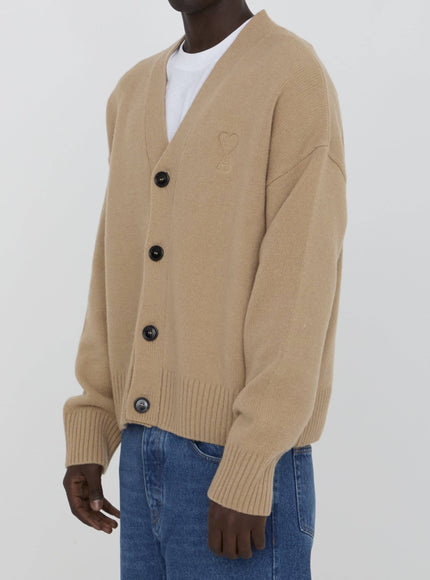 a man wearing a tan cardigan sweater and jeans