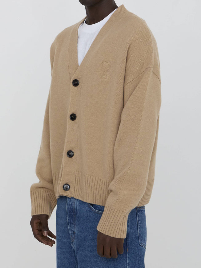 a man wearing a tan cardigan sweater and jeans