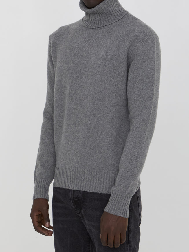 a man wearing a gray turtle neck sweater